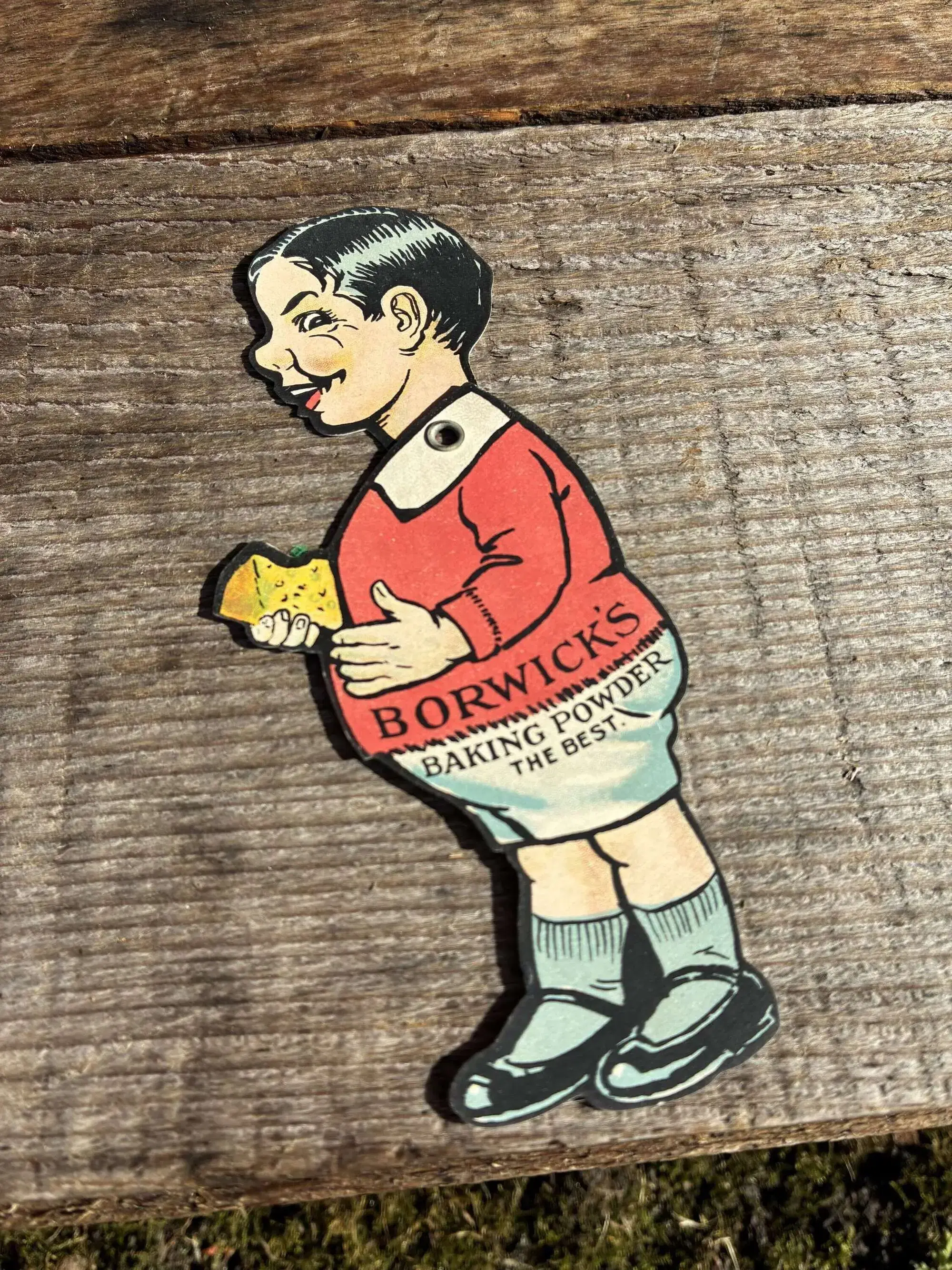 Die-cut advertising trade card of a boy in a red jumper eating cake